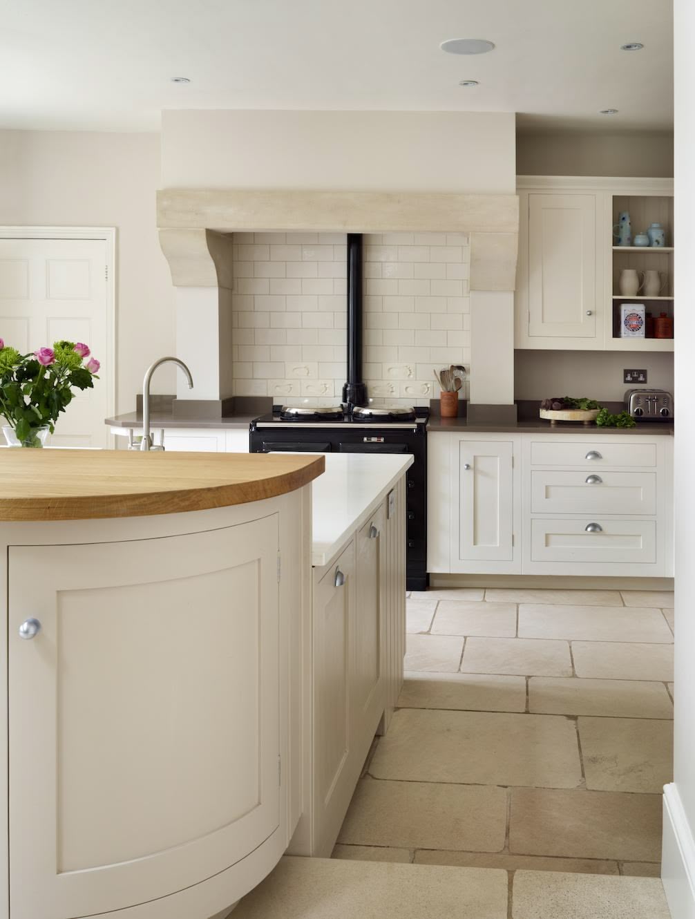 Curved beige Shaker kitchen island design with cream kitchen cabinetry
