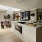 Beige kitchen island with integrated oven and grey worktop