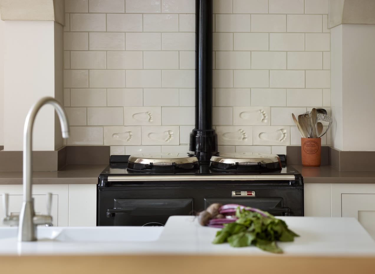 Cream tiled splashback against cooker