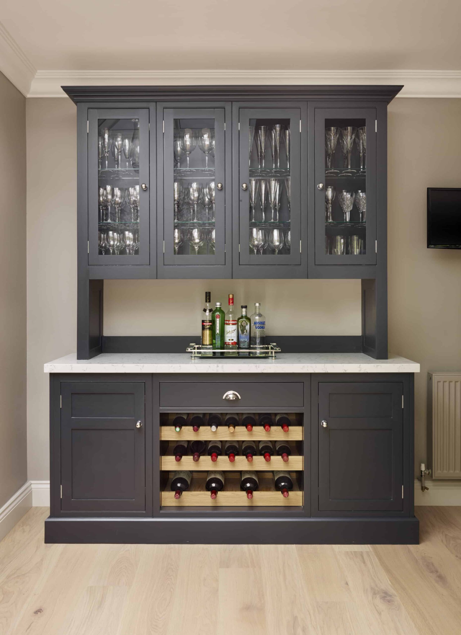 Dark grey Original kitchen cabinetry with white worktop and overhead cupboards with glass framed doors