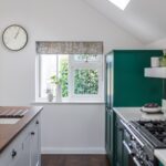 Bold green Shaker kitchen cabinetry with white kitchen island