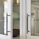 White Arbor kitchen cupboard with glass windows showing organised shelving