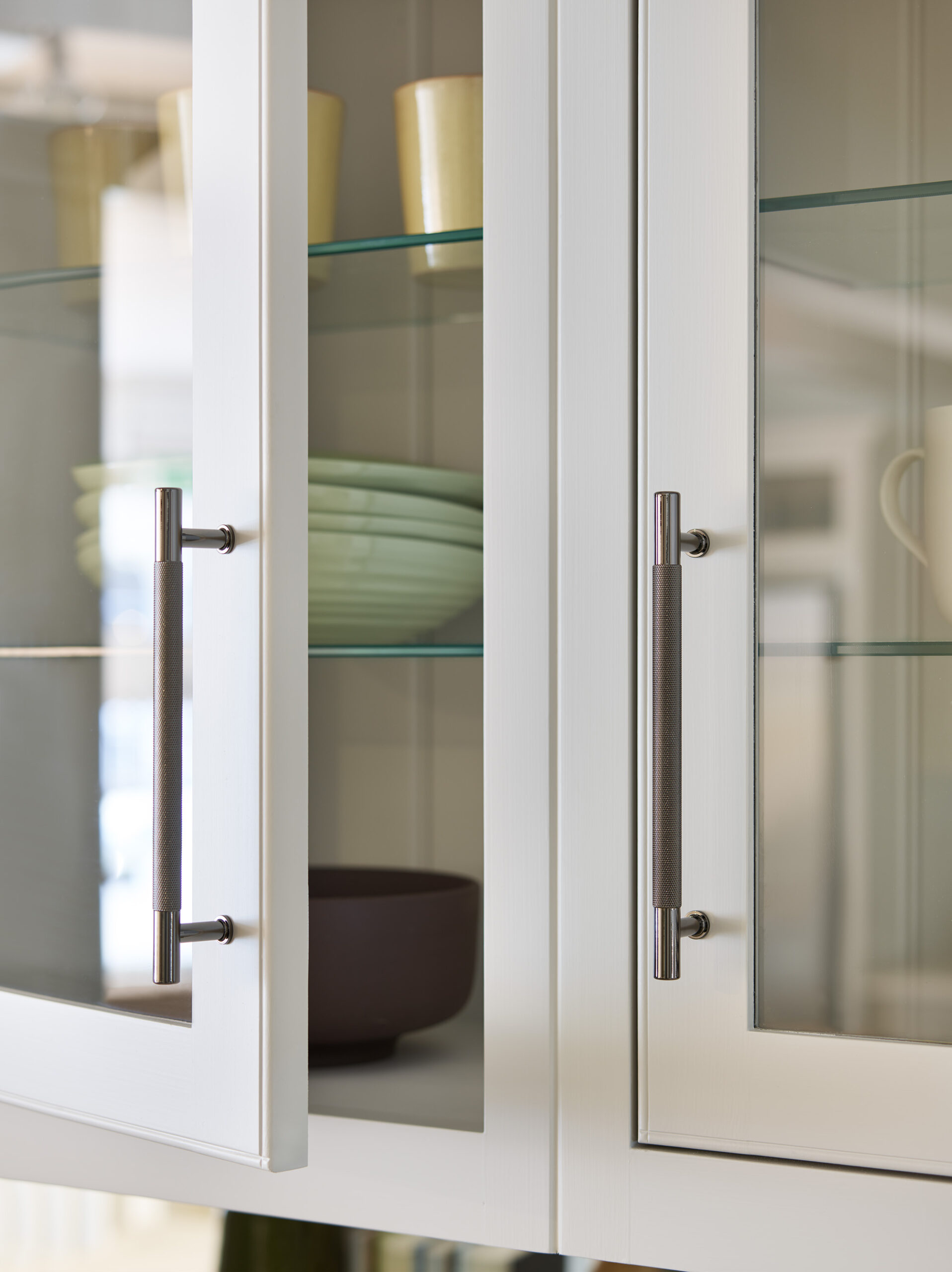White Arbor kitchen cupboard with glass windows showing organised shelving