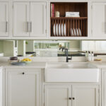 White basin sink surrounded by white Arbor kitchen cabinetry