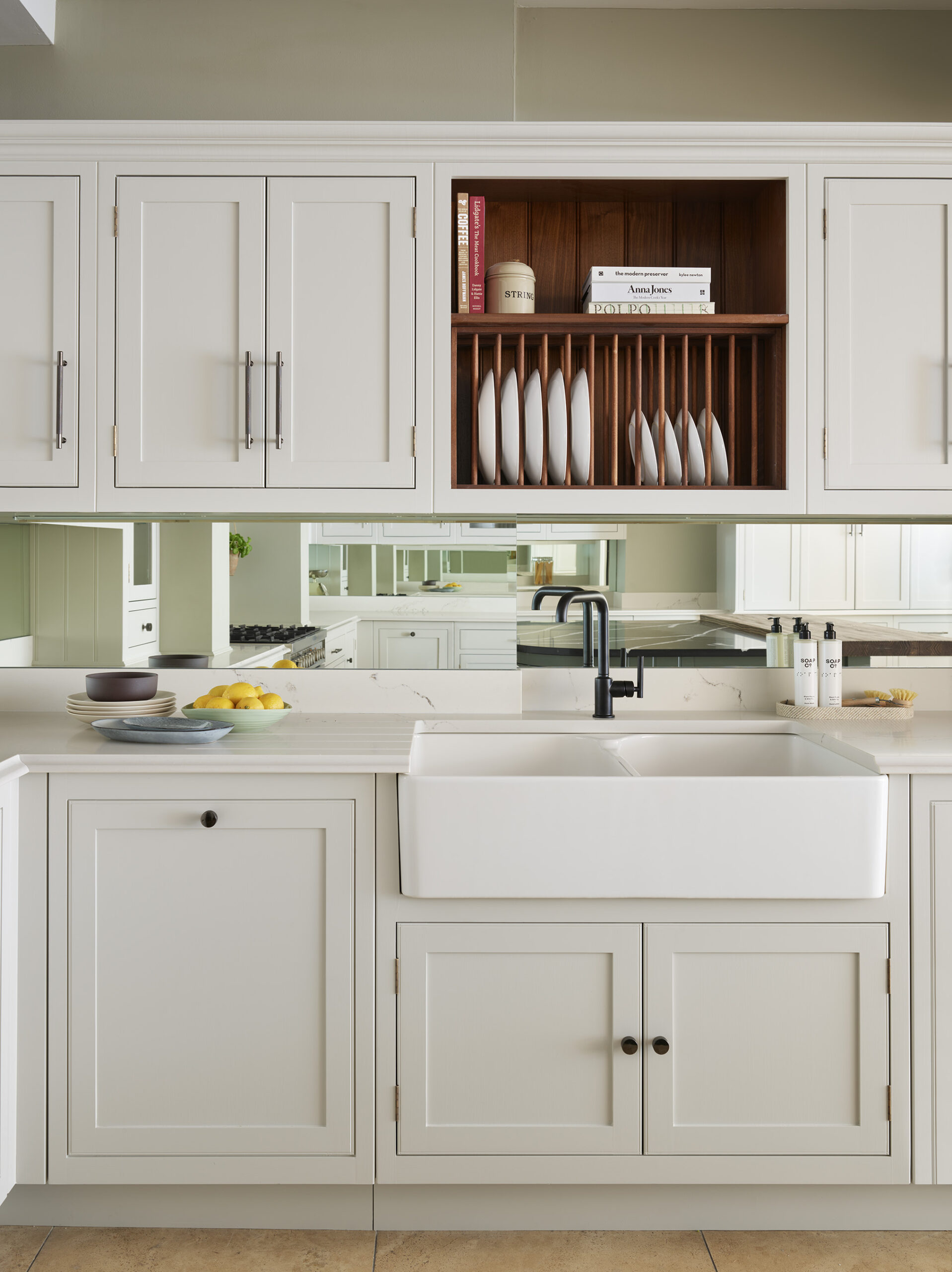 White basin sink surrounded by white Arbor kitchen cabinetry