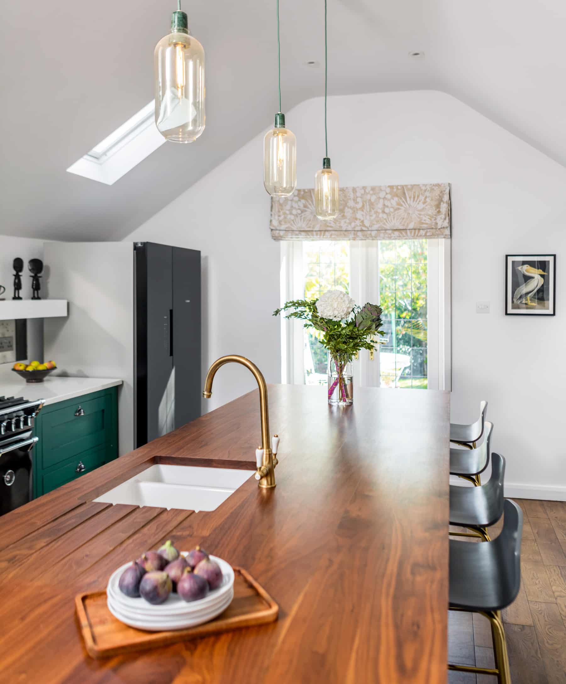 Bold green Shaker kitchen cabinetry with walnut kitchen island worktop