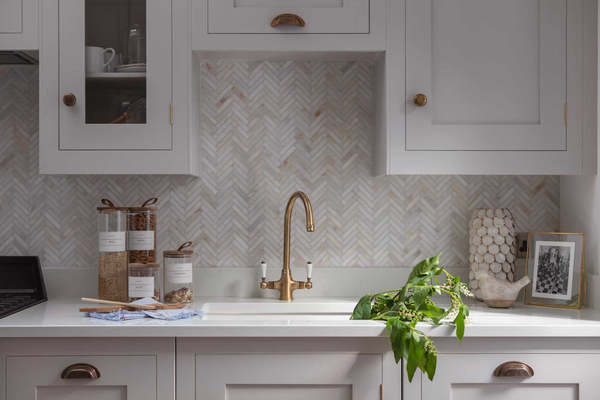 Grey kitchen cabinetry with brass handles