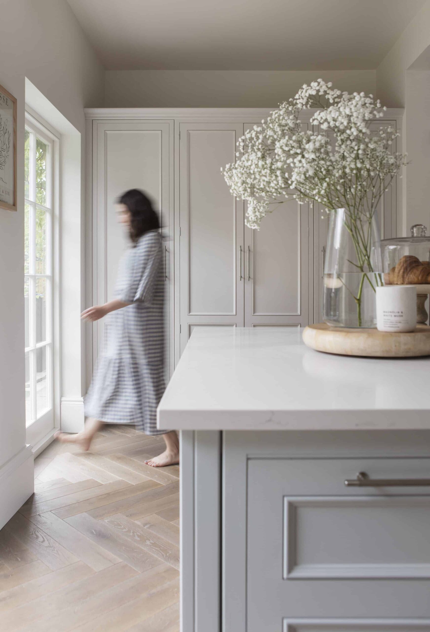 Grey kitchen island with white worktop and white kitchen cabinetry