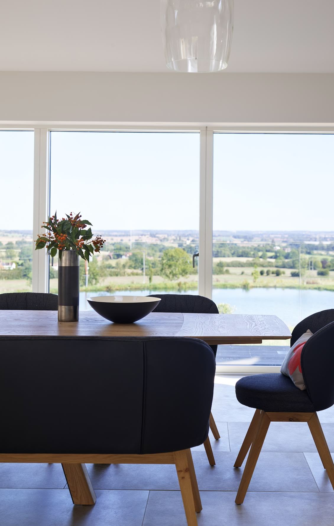 Open plan dining area overlooking view from large white framed windows