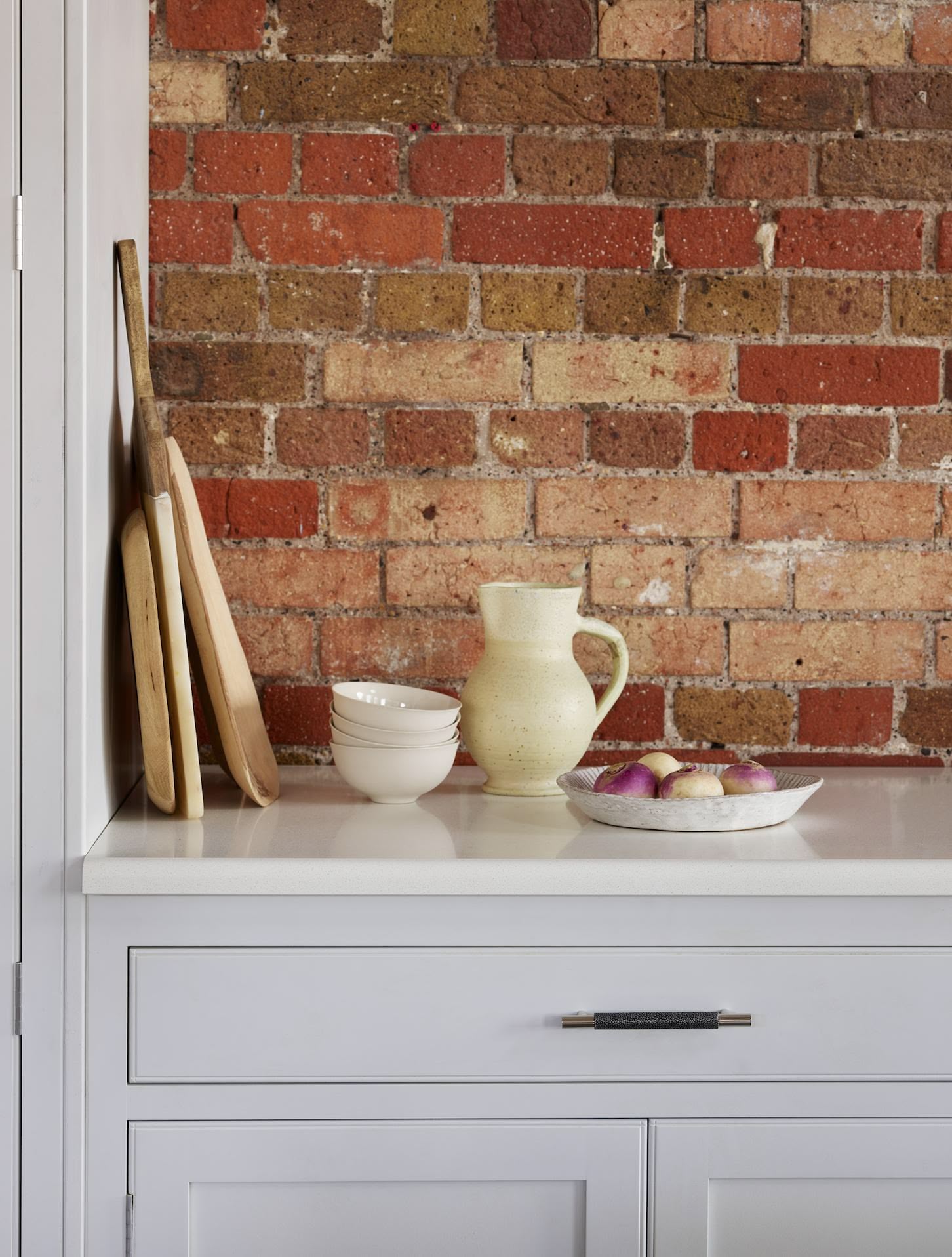 Closeup of light grey kitchen cabinetry with white worktop