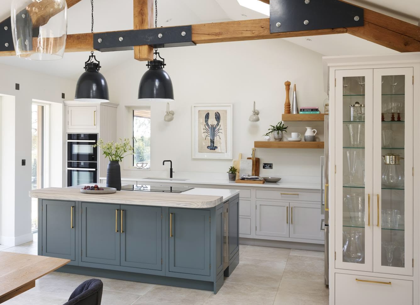 Blue kitchen island with white worktop and light grey kitchen cabinetry