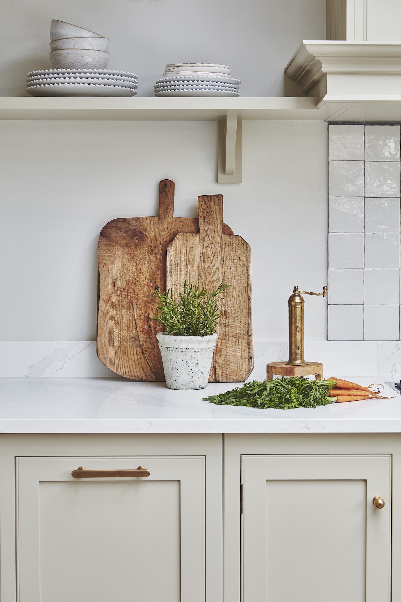 Beige Arbor kitchen cabinetry with a white worktop featuring wooden chopping boards
