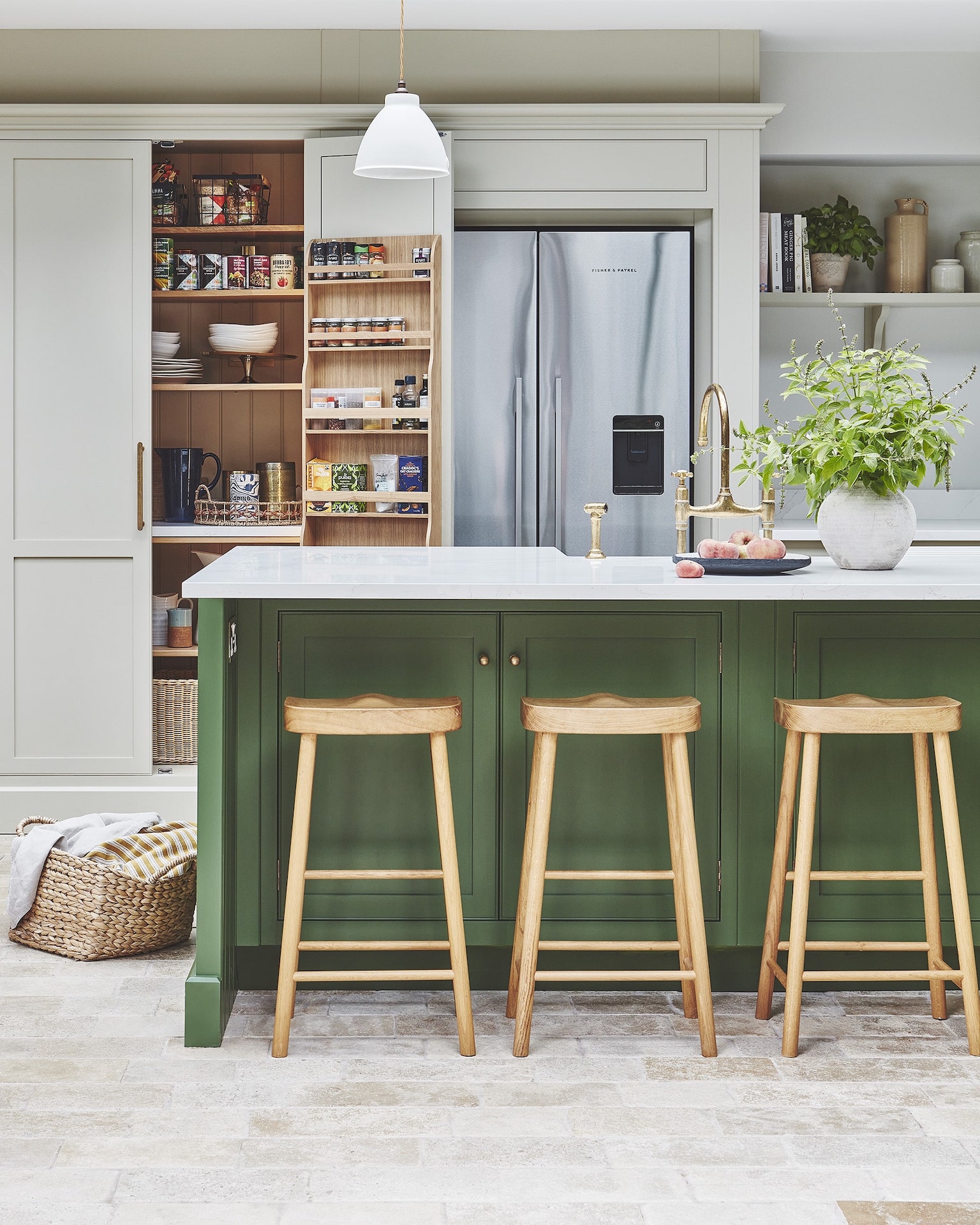 Kitchen larder and American style refrigerator with a green kitchen island featuring a white worktop