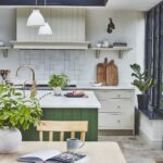 Arbor kitchen design featuring beige cabinetry and green island behind a kitchen dining area