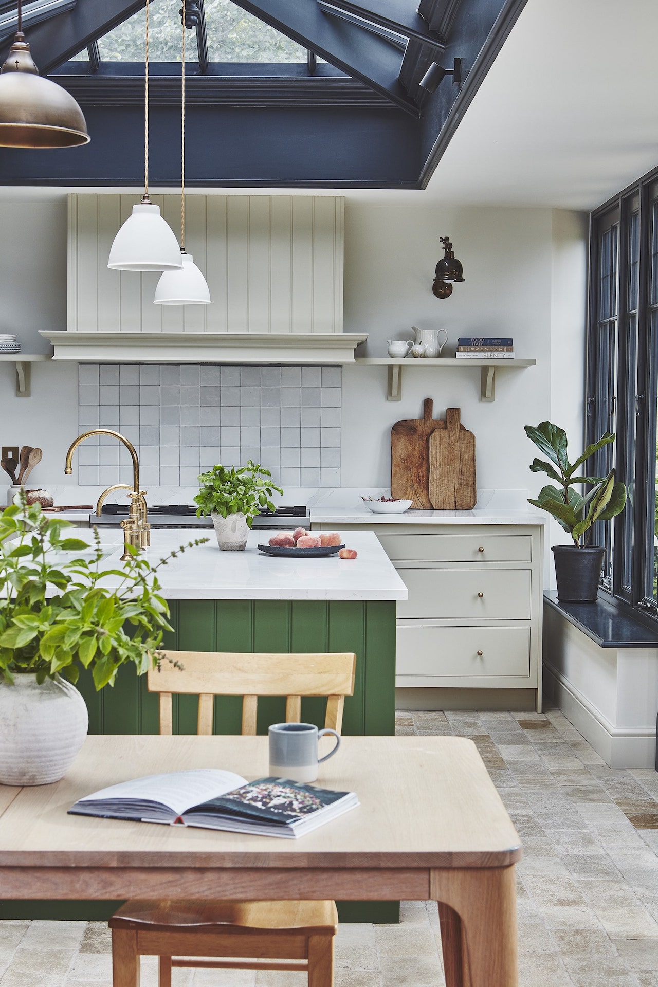 Arbor kitchen design featuring beige cabinetry and green island behind a kitchen dining area