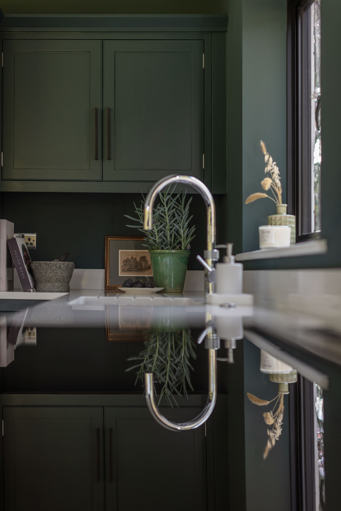 Teal Arbor kitchen cabinetry alongside a white sink and silver tap