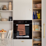 Kitchen appliance integrated within Harvey Jones X Swoon cabinetry with organised shelving