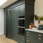 Green Shaker kitchen cabinetry with integrated appliances