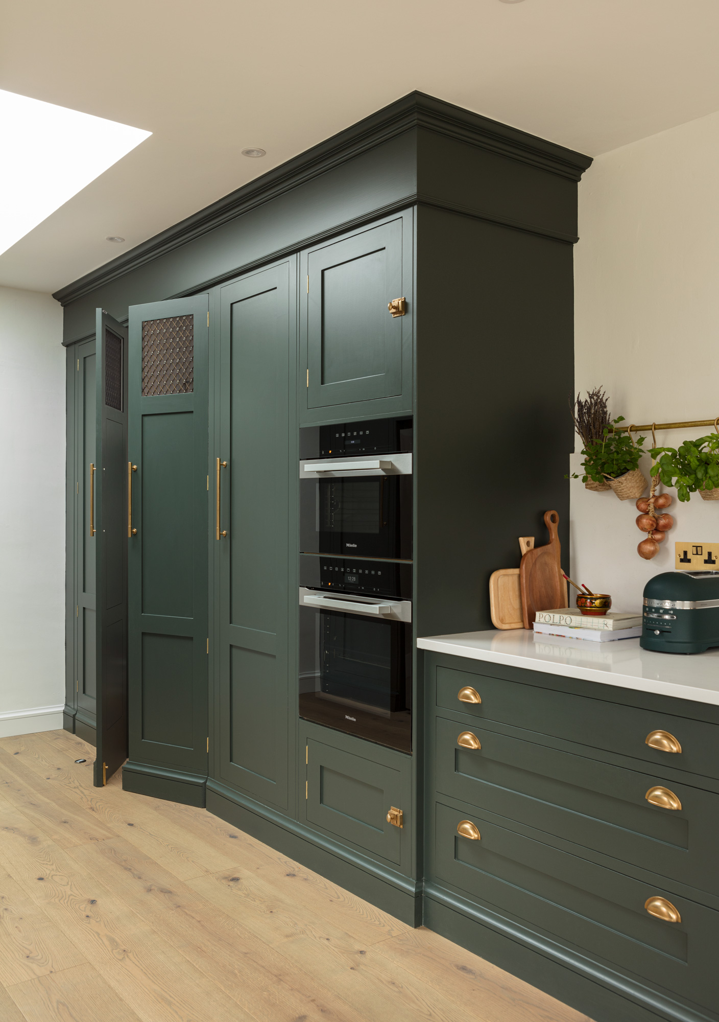 Green Shaker kitchen cabinetry with integrated appliances