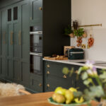 Green Shaker kitchen cabinetry with integrated appliances