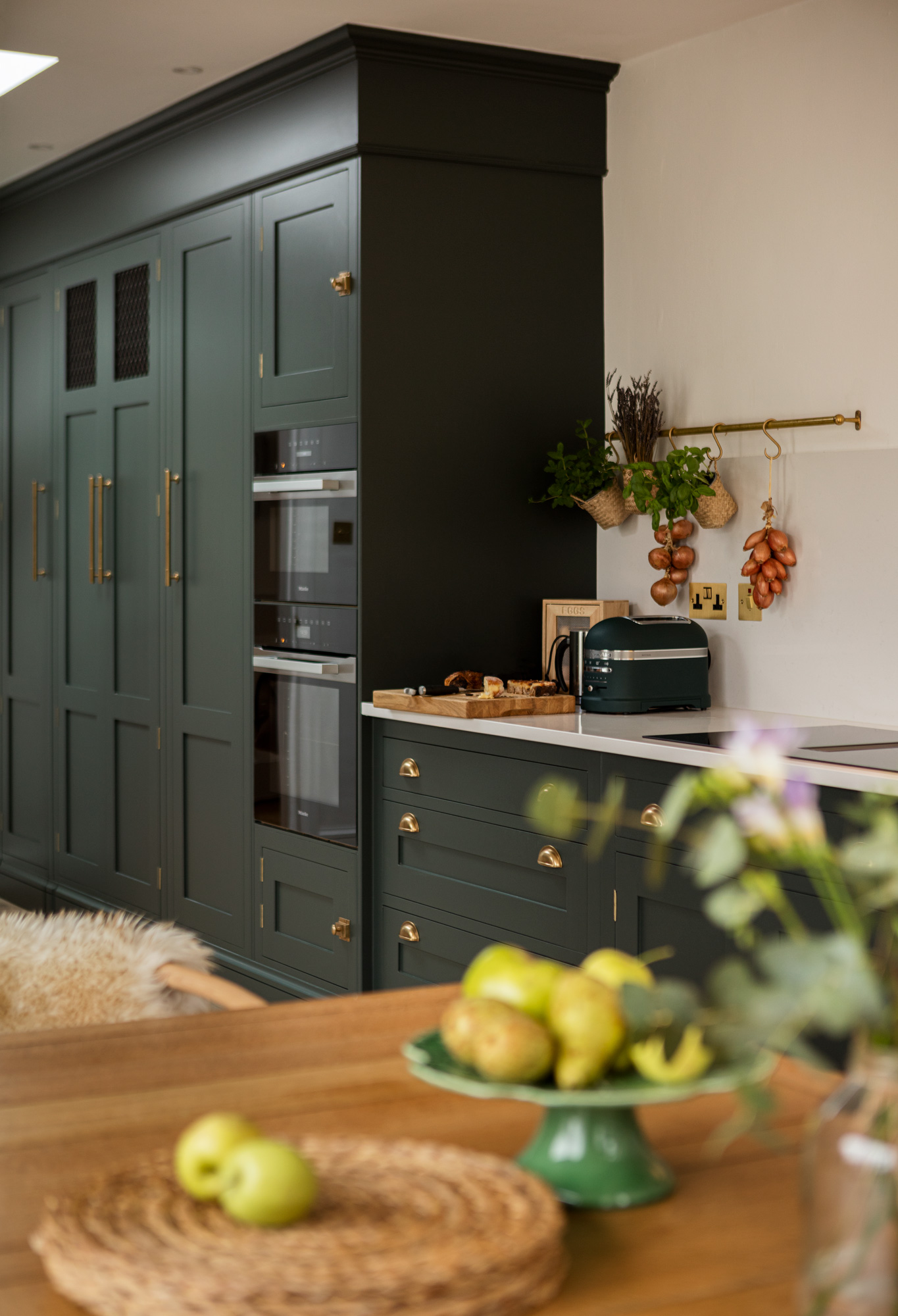 Green Shaker kitchen cabinetry with integrated appliances