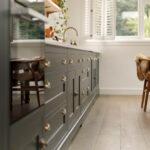 Green Shaker kitchen cabinetry with burnished brass handles