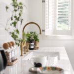 White kitchen worktop with white sink and gold tap