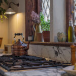 Close up of cooking area in an Arbor kitchen featuring monochrome marble worktops and splashback
