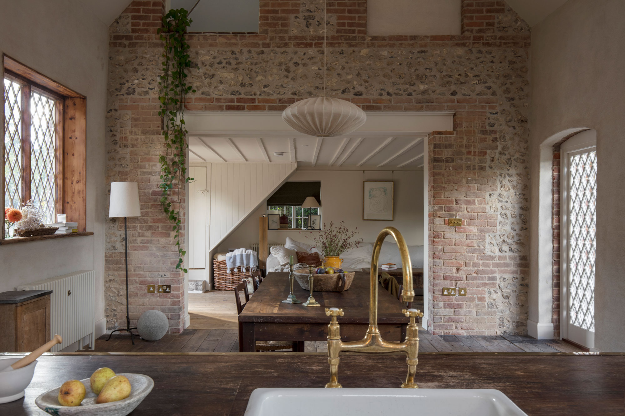 Dark wooden kitchen island featuring a white basin sink and gold tap