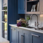 Blue Shaker kitchen cabinetry with white worktop