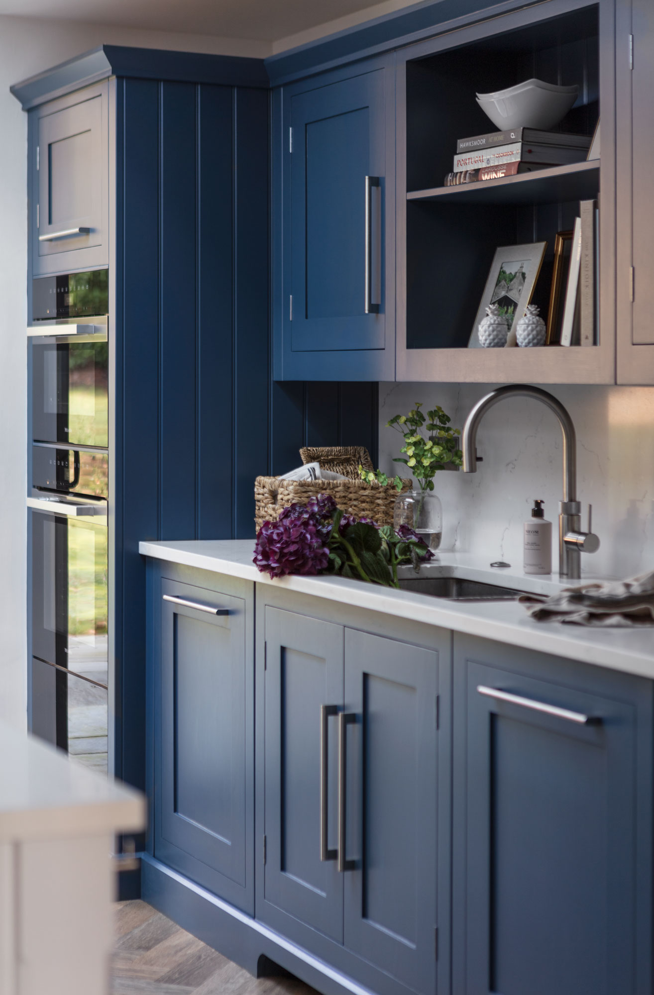 Blue Shaker kitchen cabinetry with white worktop