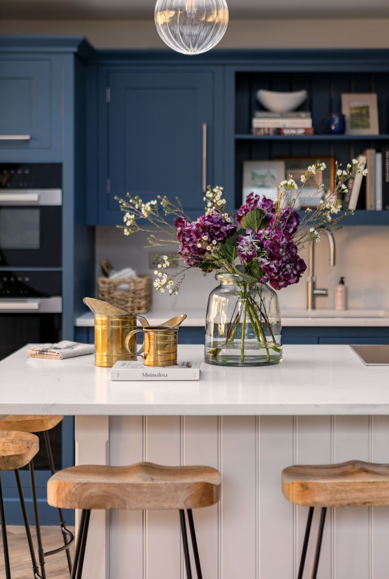 White Shaker kitchen island with white worktop and wooden bar stools