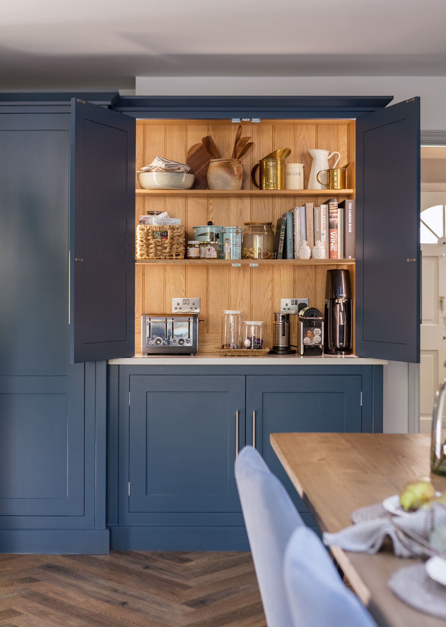 Blue Shaker kitchen unit open to reveal hidden workspace and organised shelving