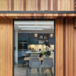 External view of navy Shaker kitchen seen through wooden framed glass door