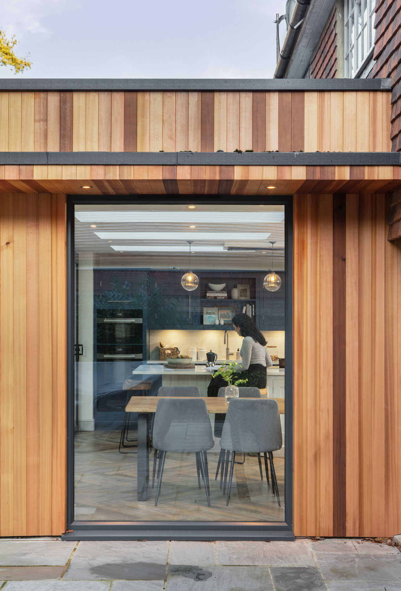 External view of navy Shaker kitchen seen through wooden framed glass door