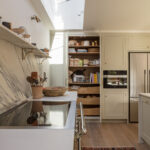 Beige Arbor kitchen cabinetry featuring white worktops and organised storage