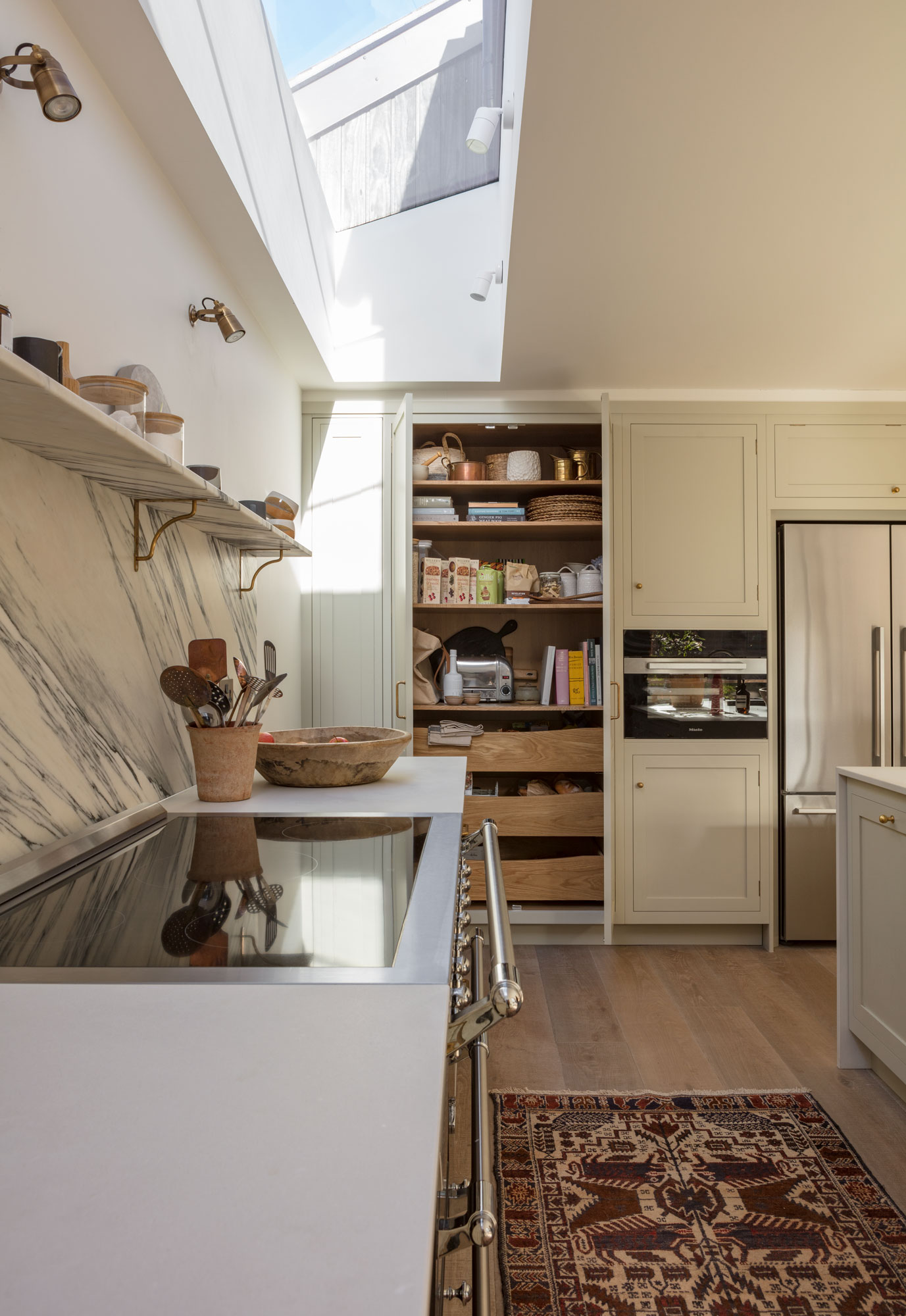 Beige Arbor kitchen cabinetry featuring white worktops and organised storage