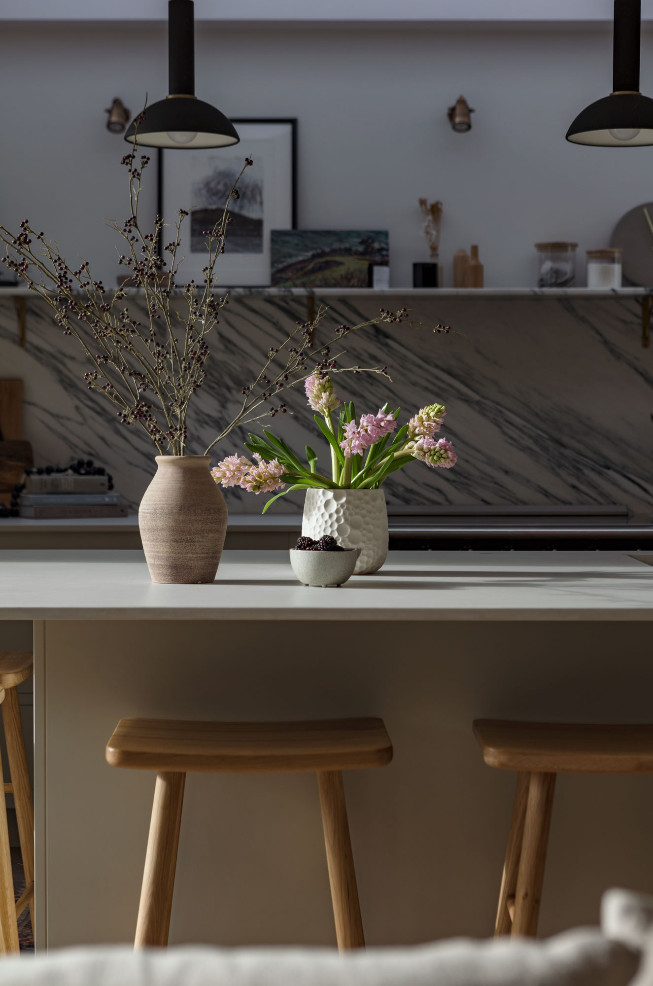 Wooden stools around a beige kitchen island with a white worktop