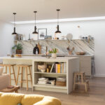 Beige Arbor kitchen cabinetry and island seen from an open plan living area