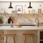 Beige kitchen island featuring a white worktop and wooden stools