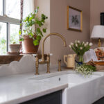 Teal Original kitchen cabinetry with white basin sink and brass tap