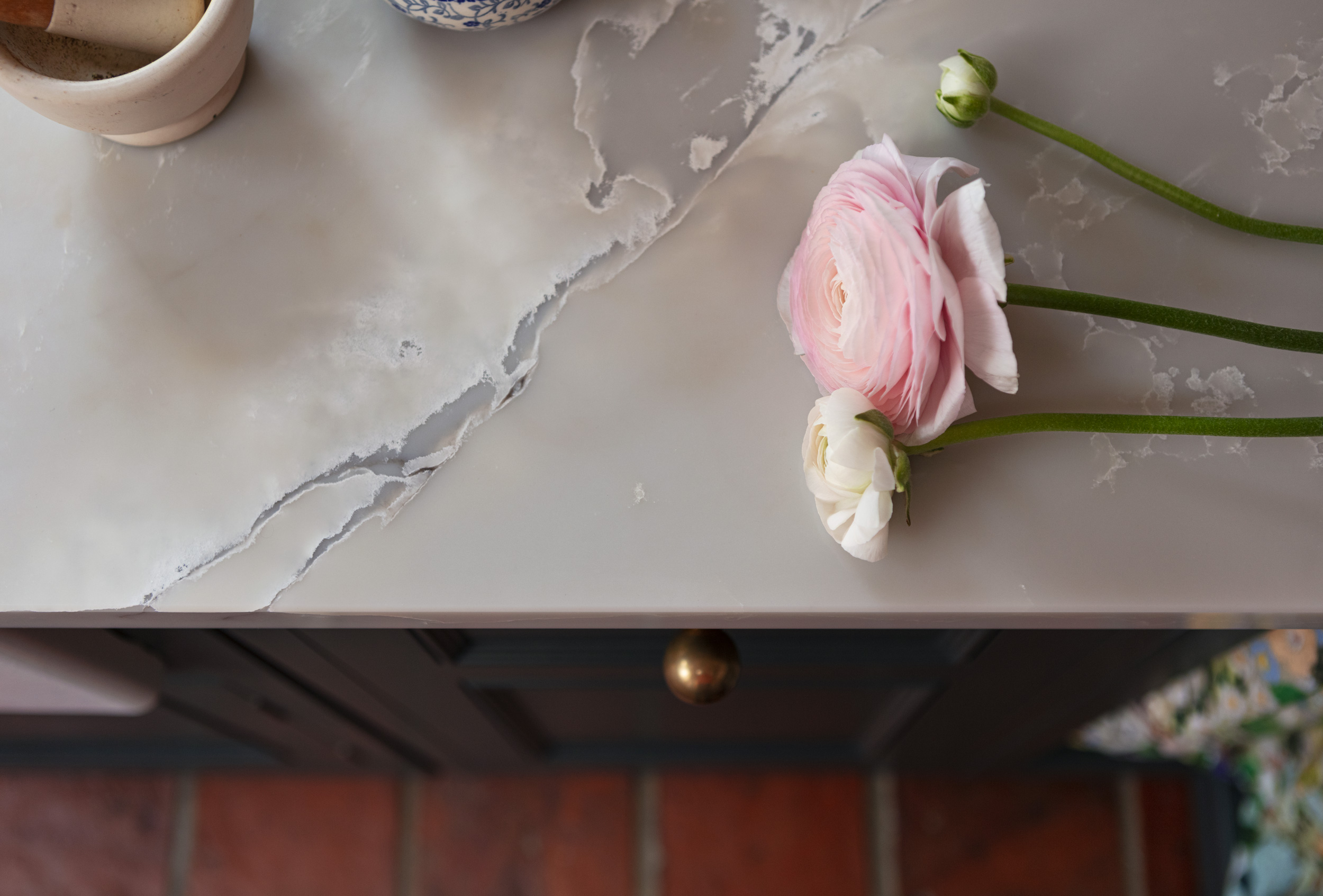 White marble worktop with teal kitchen cabinetry