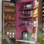 Open dark Arbor kitchen pantry with storage organisation and burgundy lining