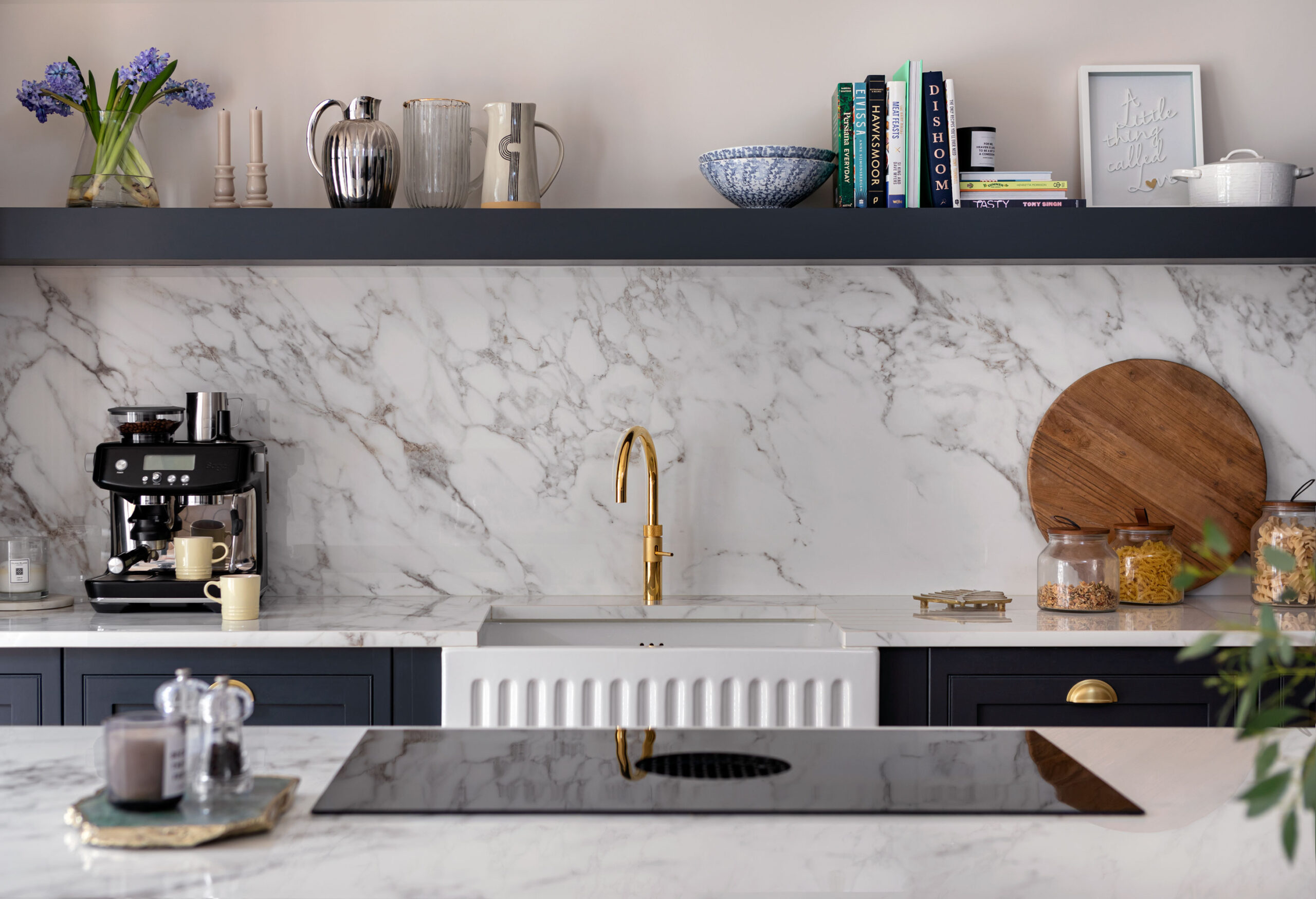 Dark Arbor cabinetry with white marble worktops featuring a white basin sink with a gold tap