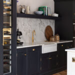 Dark Arbor kitchen cabinetry featuring white marble worktops and splashback