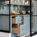 Bespoke walk-in pantry with wicker storage baskets and labelled oak drawers in blue cabinetry.