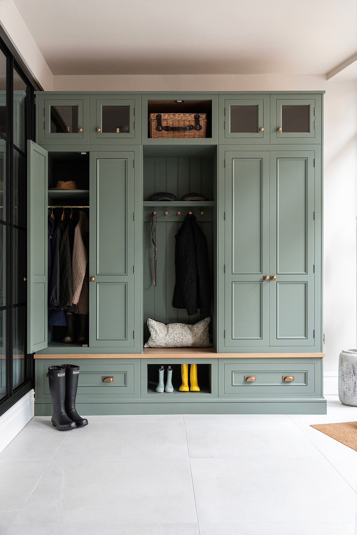 green luxury boot room with hanging storage and bench seating