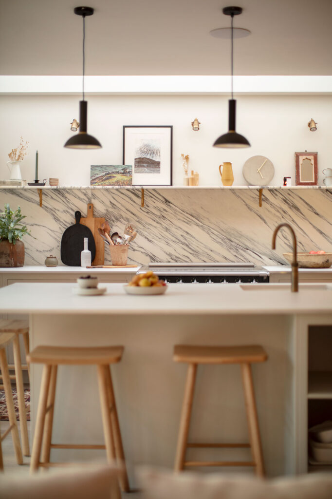 Scandi style kitchen design with neutral colour palette, bold splashback and practical island seating and storage