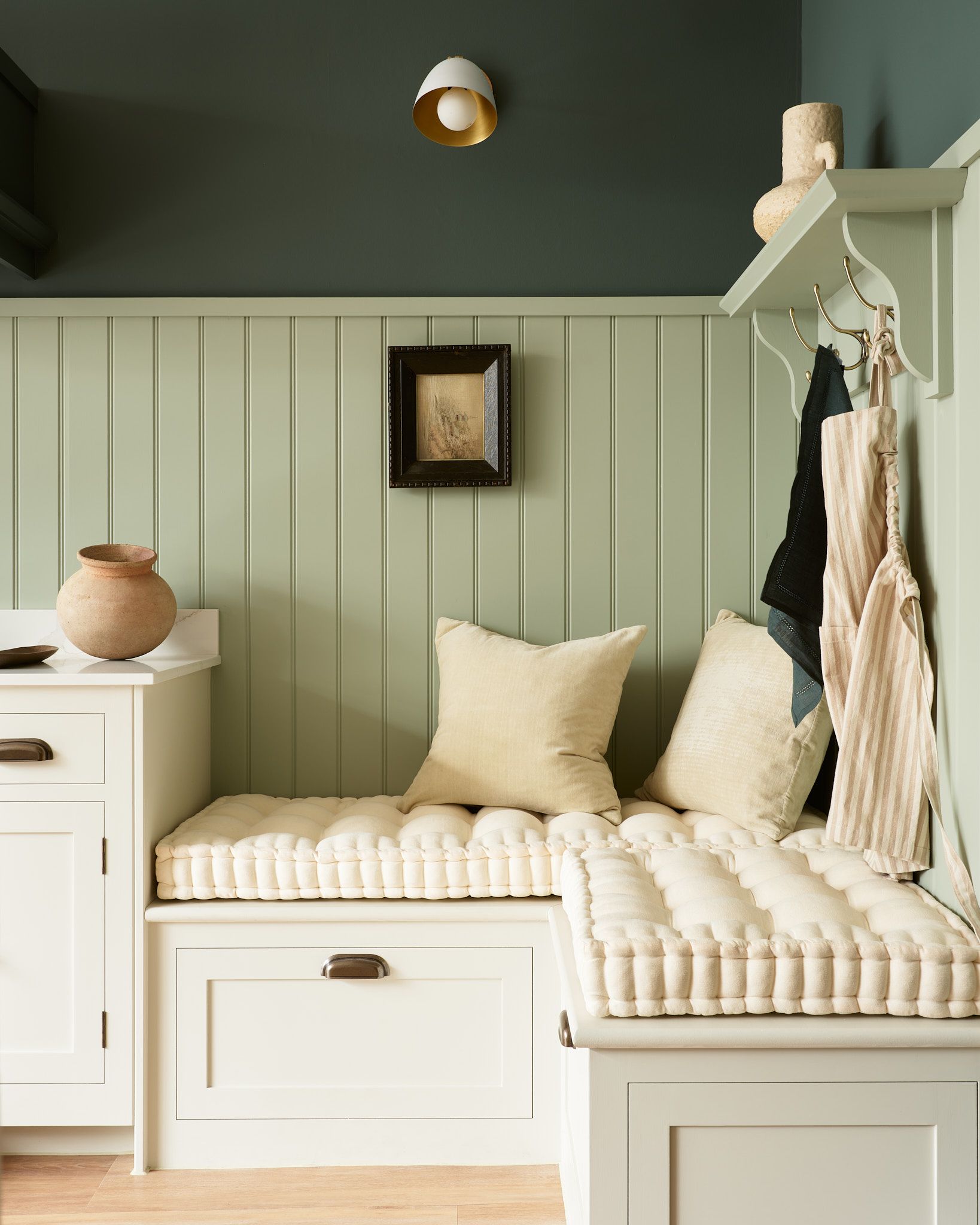 White corner bench seating featuring pale green wood cladding