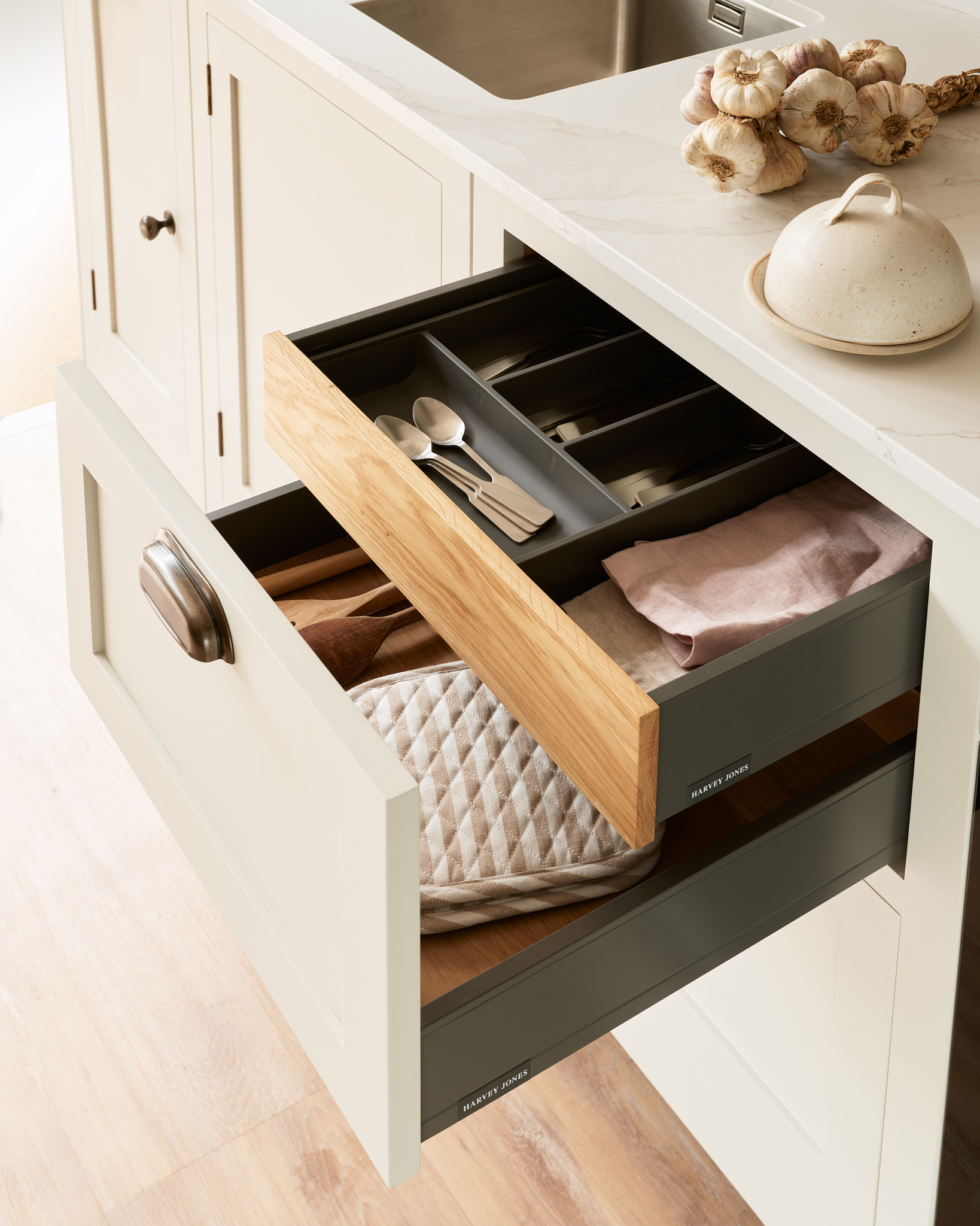 Beige Hampton kitchen drawers open to reveal dark green wooden cutlery dividers